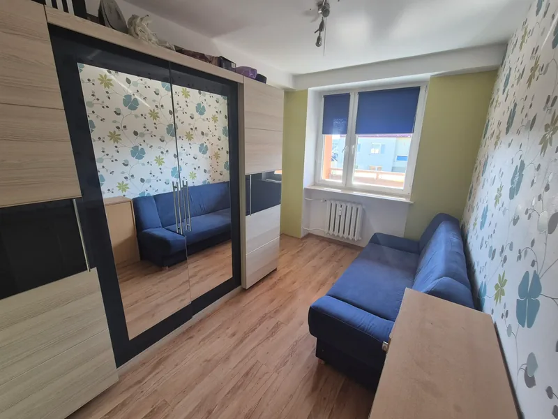 Pokój z szafą z lustrem, kanapą i oknem